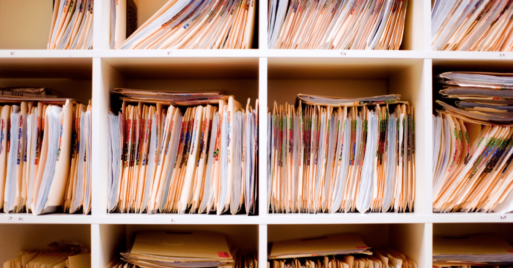 Shelves filled with neatly arranged stacks of colorful folders and papers, organized in multiple cubby compartments.