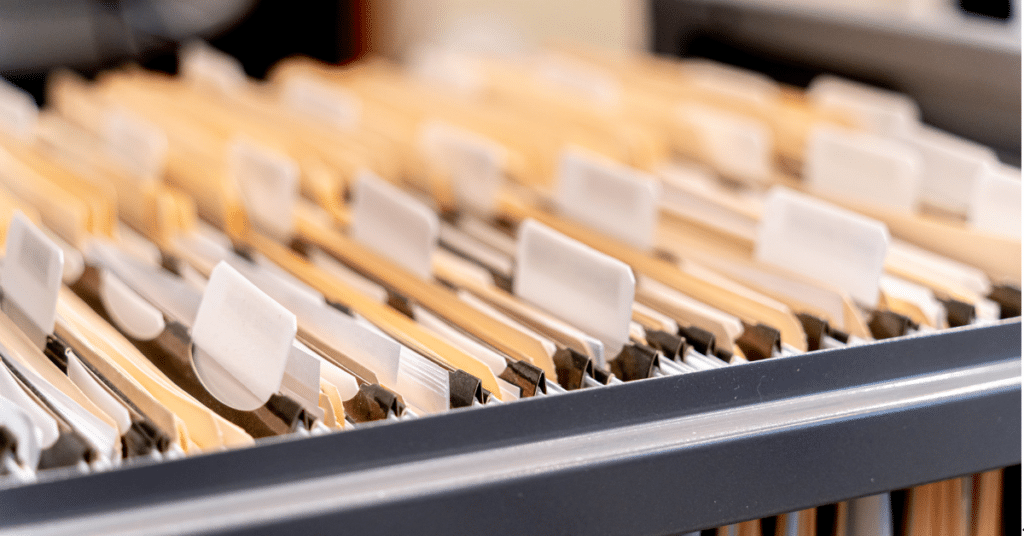 Close-up of a filing cabinet with dozens of tabbed subfolders, each filled with files